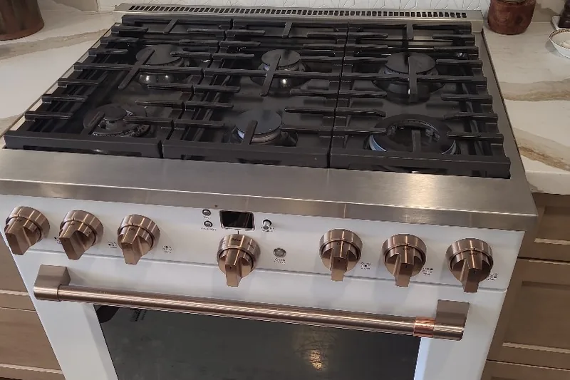 Commercial-grade luxury gas range burner manifold and thermocouple inspection